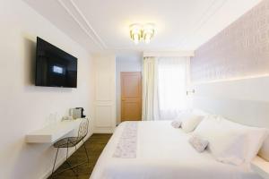 克雷塔罗Casa Oxa Hotel的一间白色卧室,配有床和电视