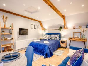 Fenny ComptonDassett View的一间卧室配有蓝色的床和沙发