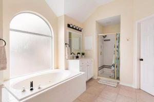 卡罗尔顿Grand Gem for Families - Games, Office, Backyard的白色的浴室设有浴缸和淋浴。
