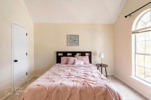 卡罗尔顿Grand Gem for Families - Games, Office, Backyard的一间卧室配有一张带粉红色床单的大床