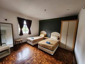 金马仑高原Little Star Hotel & Apartments的酒店客房,设有两张床和镜子