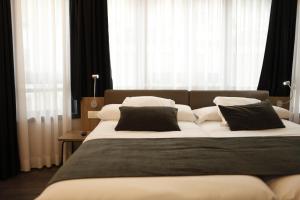 圣地亚哥－德孔波斯特拉圣地亚哥力士酒店的一间卧室配有一张大床,提供黑白枕头