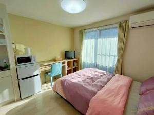 东京KIKI HOUSE 新小岩的一间卧室配有一张床和一张带微波炉的书桌