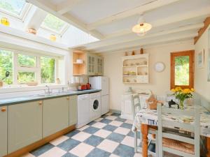 NancledraThe Barn - Ukc4055的厨房配有白色橱柜和 ⁇ 格地板