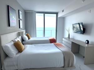 好莱坞Hyde Resort Oceanview Luxurious 2-Bedroom PH 6Pax的配有窗户的酒店客房内的两张床