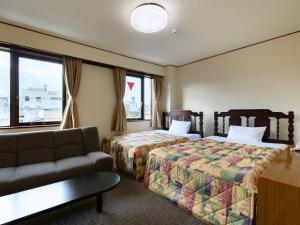 SabaeTabist Business Hotel Osamura的酒店客房,设有两张床和一张沙发