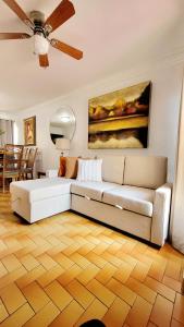 提华纳COZY CASITA EN PLAYAS DE TIJUANA的客厅配有沙发和墙上的绘画