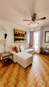 提华纳COZY CASITA EN PLAYAS DE TIJUANA的客厅配有白色沙发和吊扇