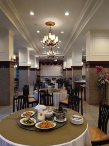 信武里府金龙度假酒店的一间用餐室,配有一张桌子和盘子