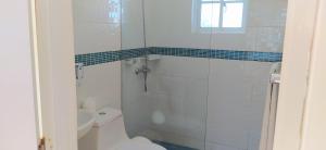 圣斐利-银港CortLang - Beach Apartments - in El Pueblito near Playa Dorada的白色的浴室设有卫生间和淋浴。