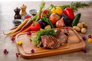 神户神户山乐TOR ROAD 酒店的餐桌上带有蔬菜和肉类的切板