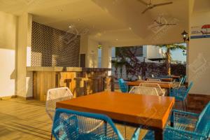 马萨特兰Planta Baja, a 10 minutos de la playa, Gran alberca y Mini Golf!!的餐厅设有木桌和蓝色椅子