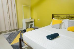 汝来5 Bedrooms Homestay with Private Pool (SEROJA)的卧室设有一张白色大床和黄色的墙壁