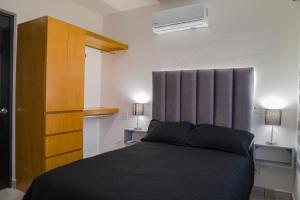 马萨特兰Planta Baja, a 10 minutos de la playa, Gran alberca y Mini Golf!!的一间卧室配有一张床和一个木制橱柜
