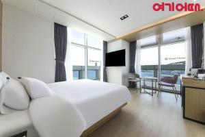 釜山Gwanganri HOTEL OCEANVIEW的酒店客房设有白色的床和客厅。