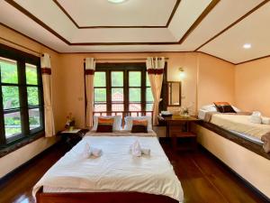 湄宏颂巴普哈多尔酒店的带2扇窗户的客房内的2张床