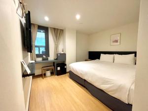 首尔Hotel Firststay Myeongdong的酒店客房设有床和窗户。