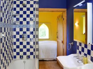 West Stour拜尔度假屋的一间带水槽和浴缸的浴室以及一张床