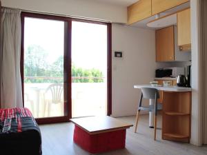 拉罗谢尔Appartement La Rochelle, 1 pièce, 2 personnes - FR-1-246-137的一间带桌子的客厅和一间带阳台的厨房