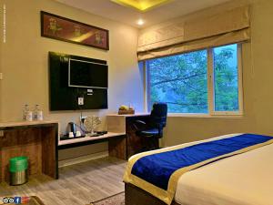 Pura RaghunāthHotel Runway Inn的一间卧室配有一张床、一张书桌和一个窗户。
