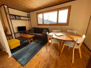 野沢Tamanegi House luxury 4 bedroom Ski Chalet的客厅配有桌子和沙发