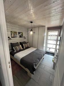 勒唐蓬Vulkan’O的一间卧室设有一张带木制天花板的大床