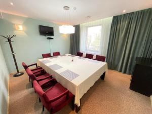 乌兰巴托乌尔古酒店的一间设有白色桌子和红色椅子的用餐室