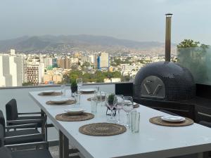 利马Moderno departamento Miraflores 360的配有酒杯和比萨饼烤箱的白色桌子