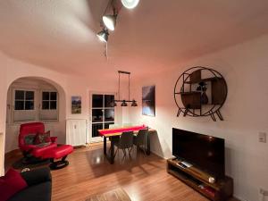 贝希特斯加登FeWo Lotti的客厅配有红色桌子和电视