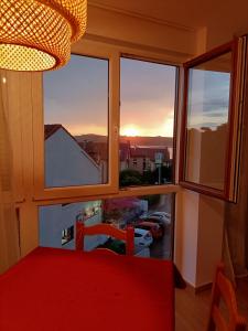 莫格罗Precioso apartamento con piscina en la playa的配有红色椅子的窗户,享有城市美景