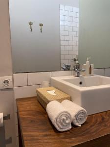 坎古布卢姆菲尔德乌马拉思酒店的浴室设有水槽和木制台面上的毛巾