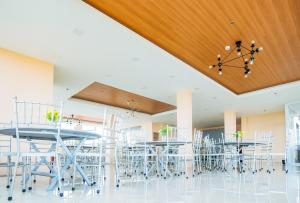 圣何塞RedDoorz Plus @ Hotel Platinum Occidental Mindoro的配有桌椅和木制天花板的客房