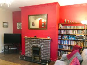 Heddon on the WallIsabella Cottage的客厅设有壁炉和红色的墙壁