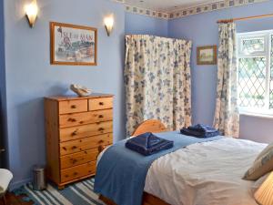 Heddon on the WallIsabella Cottage的一间卧室配有一张床、一个梳妆台和一扇窗户。