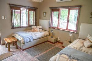 GroblersbrugKlippan River Lodge的一间卧室设有两张床和两个窗户。