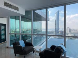 迪拜Luxurious Penthouses的一间带两把椅子的客厅,享有城市美景