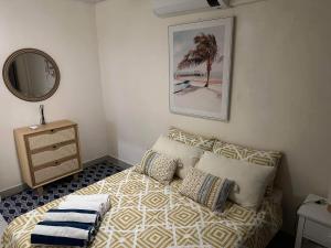 维拉港Bamboo Villa的一间卧室配有带枕头和镜子的床