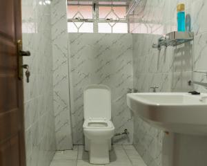 RuiruGuesthouse in Kamakis Eastern Bypass的浴室配有白色卫生间和盥洗盆。