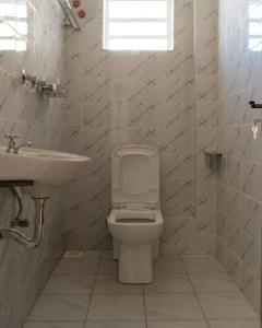RuiruGuesthouse in Kamakis Eastern Bypass的白色的浴室设有卫生间和水槽。