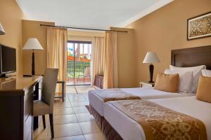 考拉亚湾达伊尔梅迪纳度假村的酒店客房配有一张床、一张书桌和一台电视。