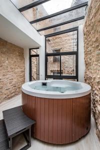 波凯兰特ABBI SUITES Casa Rural, Suites & Spa的设有一个大浴缸的大窗户
