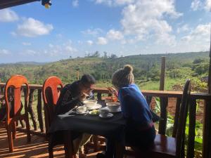Môndól KiriNatural House Farm Stay的坐在桌子旁的两位妇女,在阳台上吃食物