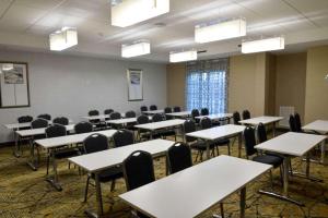 休斯顿Comfort Inn & Suites Houston I-45 North - IAH的一间空的教室,配有桌椅和灯