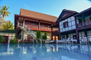 Muang KhôngSenesothxuene Hotel的一座带游泳池的度假村,位于一座建筑前