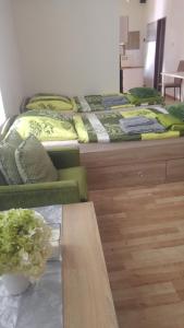 班斯卡-比斯特里察Kapitula centrum的一张桌子和一张沙发的房间里设有两张床