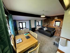 斯旺西Rhossili's Retreat - AONB - Gower Rural Sleeps up to 6的客厅配有桌子和沙发