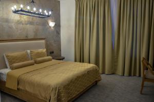 巴库Shirvanshah Hotel的一间卧室配有一张床和一个吊灯