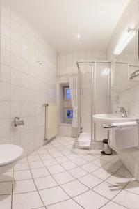 LastrupLandhaus Lastrup的白色的浴室设有水槽和淋浴。