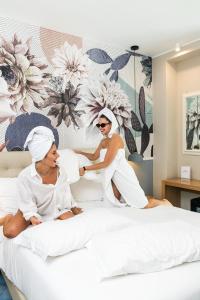 帕埃斯图姆索加利斯酒店的两名女性坐在床上,穿着毛巾