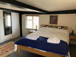 伍德布里奇Charming holiday apartment in central Woodbridge的一间卧室配有一张床,上面有两条毛巾